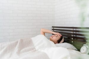 風邪で寝込んでいる女性の写真